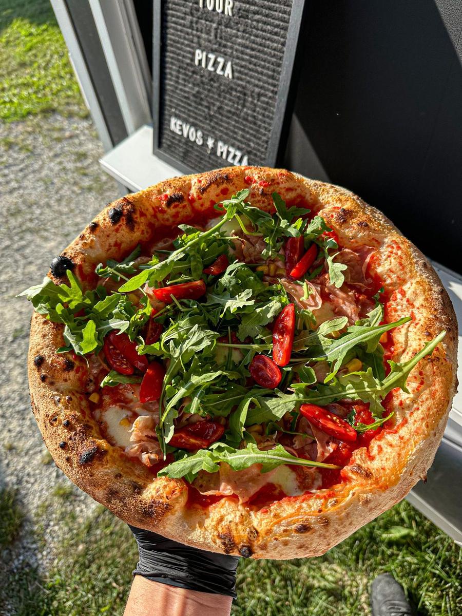 Zwei frisch gebackene Pizzen auf einem Holzbrett