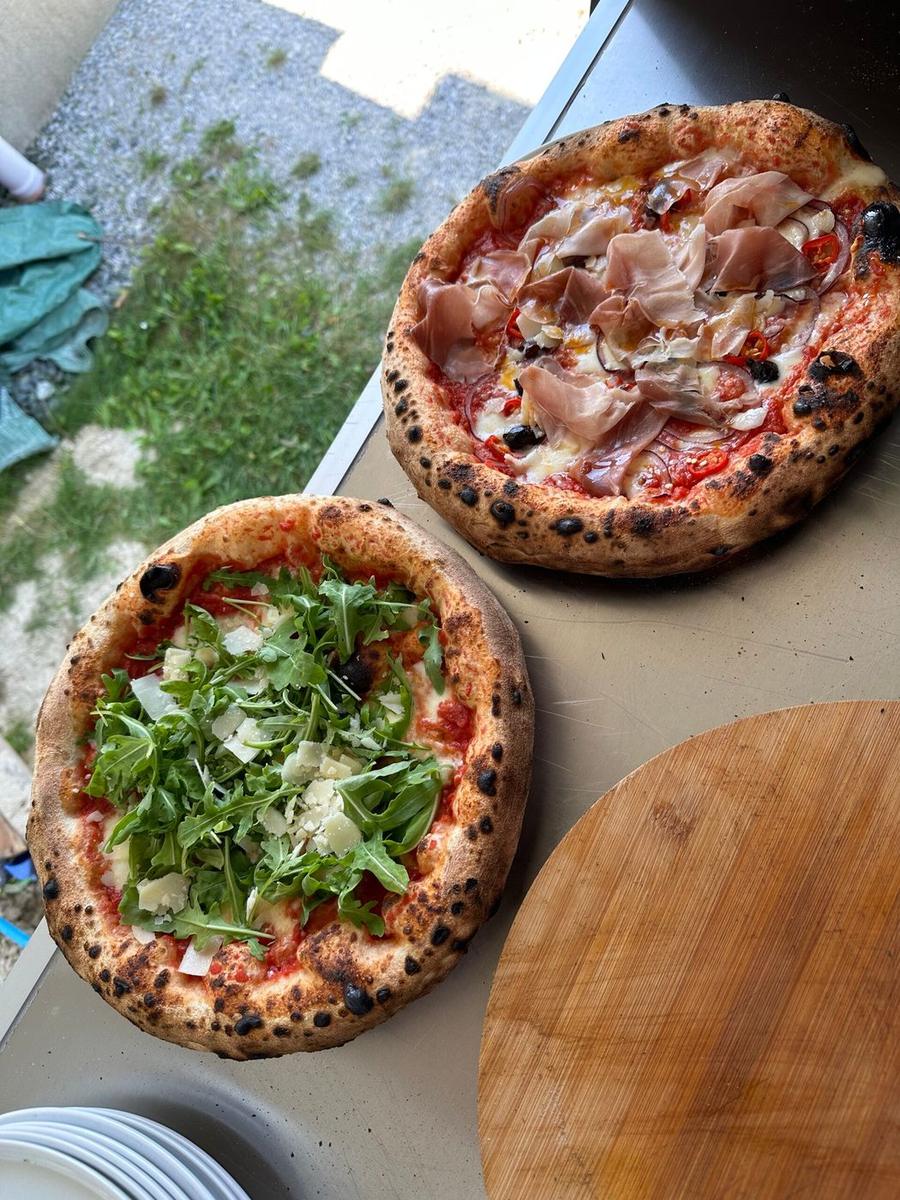 Frisch gebackene Pizza, im Freien in die Kamera gehalten