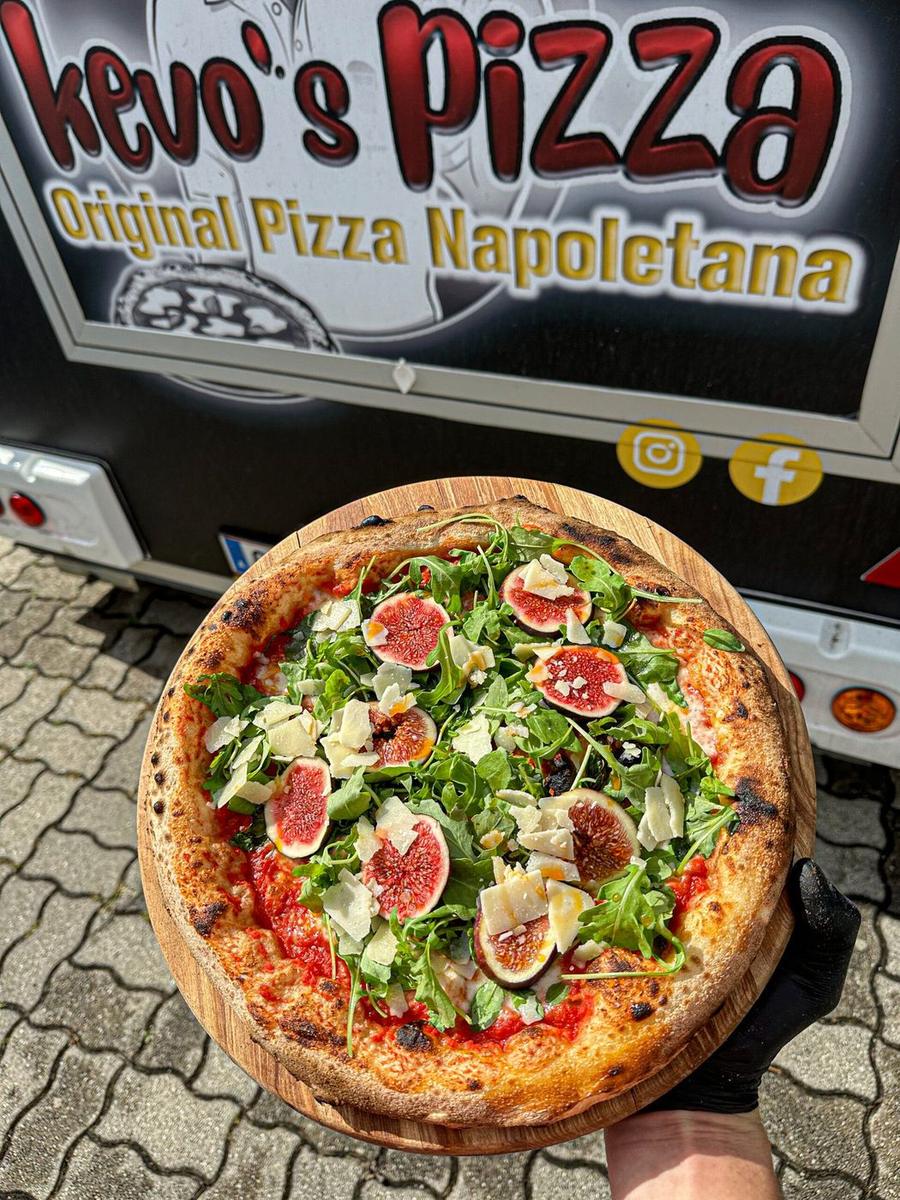 Neapolitanische Pizza mit Salami, Oliven und Basilikum in Nahaufnahme